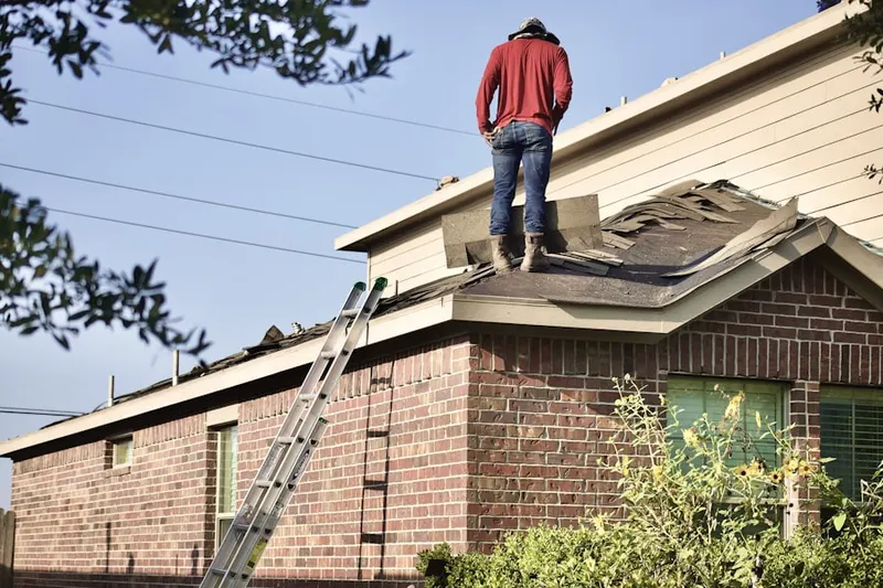 Professional roofer working on a residential roof in Harness Woods